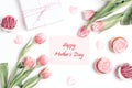 Mothers day message with cupcakes, tulips and gift on white background. Mothers day concept