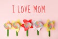 Mothers day message I LOVE MOM with handicraft flowers on pastel pink board, creative idea, holiday card, kidergarten day care diy