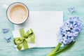 Mothers Day spring holiday card with empty notebook for greeting text with cup of coffee, gift or present box and hyacinth flowers Royalty Free Stock Photo