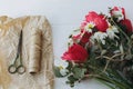Mothers day. Stylish red tulips, daffodils bouquet and craft paper, scissors and twine on white wood Royalty Free Stock Photo