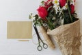 Mothers day. Tulips, daffodils bouquet with greeting card, pencil, scissors, twine on rustic wood Royalty Free Stock Photo