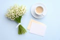 Mothers Day or Wedding flat lay composition with cup of coffee, bouquet of lily of the valley flowers, love letter with blank