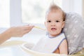 Mothers feeding the baby with cottage cheese