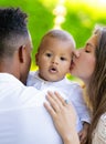 Mothers kissed baby. Close up portrait of mother kissing multiracial baby. Mother kiss child, father caring baby Royalty Free Stock Photo