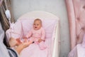 Little baby girl watching a hanging mobile.