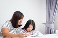 The mother taught her daughter how to do housework on the desk at home.