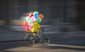 Motion blur of Asian balloon seller riding bicycle on the street Royalty Free Stock Photo