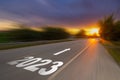 Motion blur empty asphalt road and New year 2023 concept. Driving on an empty road to Goals 2023 with sunset Royalty Free Stock Photo