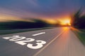 Motion blur empty asphalt road and New year 2023 concept. Driving on an empty road to Goals 2023 with sunset Royalty Free Stock Photo