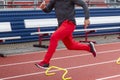 Motion blur on runner running fast over six inch hurdles on a track