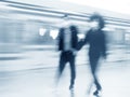 Motion blur image of silhouettes of two boys walking in a subway.