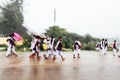 Motion blur of Indian students walking in the rain on the road. They are going to school bus while raining
