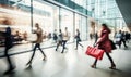 motion blur of people with shopping bags in a busy shopping mall. retail sale and discount Royalty Free Stock Photo