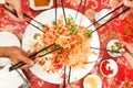 Motion blur of people tossing yusheng or yee sang, a dish during Chinese New Year for luck and prosperity