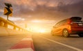 Motion blur of red car driving on curve concrete road with a traffic sign. Road trip on summer vacation. Car drive on the street.