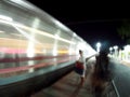 Motion blur shot of fast moving train at night with blur unidentified human figure