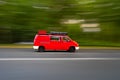 Motion Blur Shot Of A Red Camper Van Driving Fast In A Road