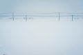 Telephone lines and small village in white snow field Royalty Free Stock Photo