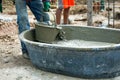 Motion blurred hand of worker carrying the bucket of mixed cement out of the wagon and delivers to colleagues at the construction