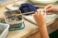 Motion blurred hands of girl molding the clay work with wet mud in plastic tray