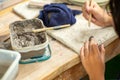 Motion blurred hands of girl molding the clay work with wet mud in plastic tray