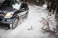 Big suv car going fast on a snow covered forest road Royalty Free Stock Photo