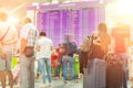 Motion blurred travellers crowd looking at fligh feparture and arrival timetable at airport terminal. Travel and tourism concept.