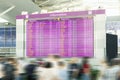 Motion blurred travellers crowd looking at fligh feparture and arrival timetable at airport terminal. Travel and tourism concept.