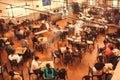 Motion blurs from moving students inside crowded city cafe with asian menu, local food and masala tea