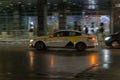 Motion city street scene with yellow taxi vehicle. Fast moving yandex taxi car on Moscow wet winter streets. Blured auto motion at