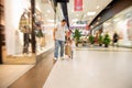 Motion effect. concept of fast shopping on the run. craft paper bag in focus, carried by dad and little girl in the mall
