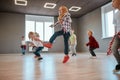 In motion. Group of cute little boys and girls studying modern dance in studio. Children jumping while having a