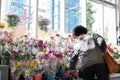 Motion of of people buying orchid on display flower rack inside price smart foods store