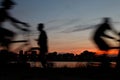 motion picture of cyclist people passing by the edge of the lagoon in the city of Rio de Janeiro at the end of the day