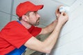 Worker installing or adjusting motion sensor detector on the ceiling Royalty Free Stock Photo