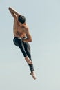 motion shot of handsome shirtless dancer in jump against