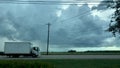 Motion time-lapse of a dark thunderstorm with traffic moving by