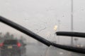 Motion of windscreen wipers on windshield with blurred traffic d