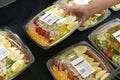 Motion of woman`s hand picking salad inside superstore
