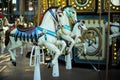 Motioned blurred picture of horse of the carousel with defocused horses and bokeh lights in background