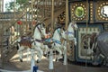 Motioned blurred picture of horse of the carousel with defocused horses and bokeh lights in background