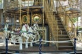 Motioned blurred picture of horse of the carousel with defocused horses and bokeh lights in background