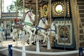 Motioned blurred picture of horse of the carousel with defocused horses and bokeh lights in background