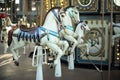 Motioned blurred picture of horse of the carousel with defocused horses and bokeh lights in background