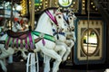 Motioned blurred picture of horse of the carousel with defocused horses and bokeh lights in background