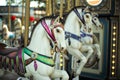 Motioned blurred picture of horse of the carousel with defocused horses and bokeh lights in background