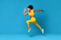 African Lady In Fitwear Exercising Jumping Over Blue Studio Background Royalty Free Stock Photo