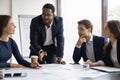 Motivated african American male boss brainstorm with colleagues at briefing