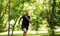 Motivated African American sprinter training for race at summer park, copy space