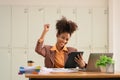 Motivated African American woman looking at tablet screen and celebrating success, excited by good news in email or Royalty Free Stock Photo